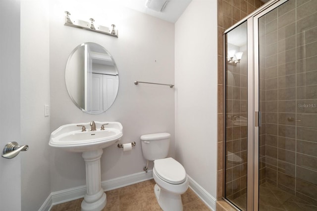 bathroom with toilet, tile patterned floors, and a shower with door