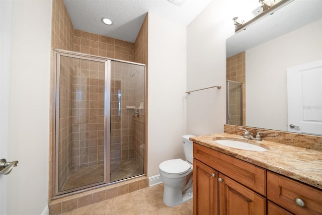 bathroom featuring a textured ceiling, toilet, walk in shower, vanity, and tile patterned flooring