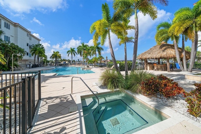 view of pool with a patio and a hot tub