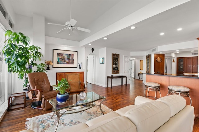 living room featuring ceiling fan and dark wood-type flooring