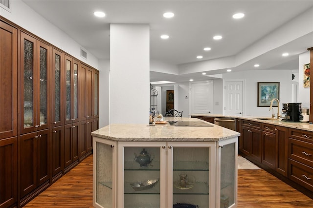 kitchen with an island with sink, light stone countertops, dark wood-type flooring, and stainless steel dishwasher