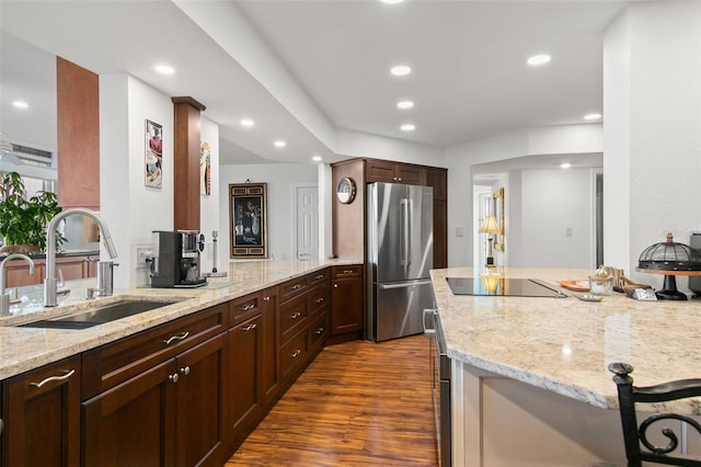 5153 Isla Key Blvd S Unit 412, Saint Petersburg, FL 33715 - kitchen with freestanding refrigerator, black electric stovetop, light stone counters, a sink, and dark wood finished floors