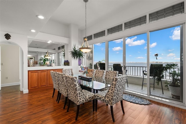 dining room featuring a water view and dark hardwood / wood-style floors