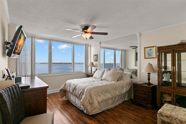 bedroom featuring multiple windows, ornamental molding, dark hardwood / wood-style floors, and ceiling fan