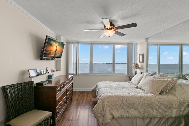 bedroom featuring a textured ceiling, dark hardwood / wood-style floors, ornamental molding, ceiling fan, and expansive windows