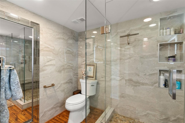5153 Isla Key Blvd S Unit 412, Saint Petersburg, FL 33715 - full bathroom featuring visible vents, wood finished floors, toilet, tile walls, and a stall shower