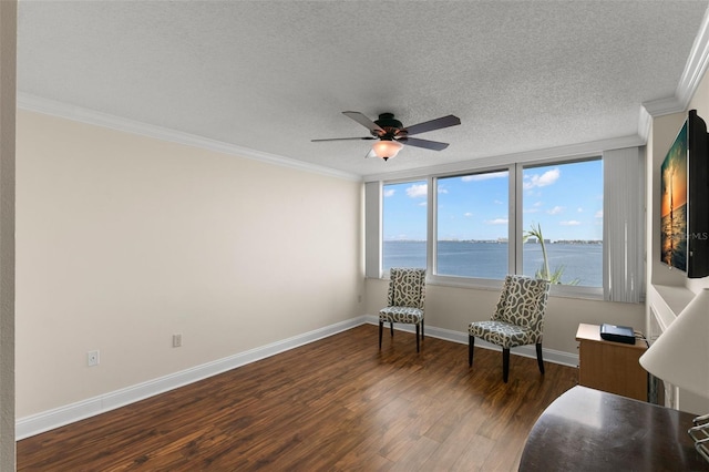 living area with ceiling fan, a textured ceiling, crown molding, and dark hardwood / wood-style flooring