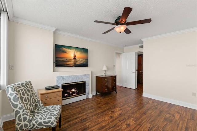 living room featuring ceiling fan, a high end fireplace, a textured ceiling, and dark wood-type flooring