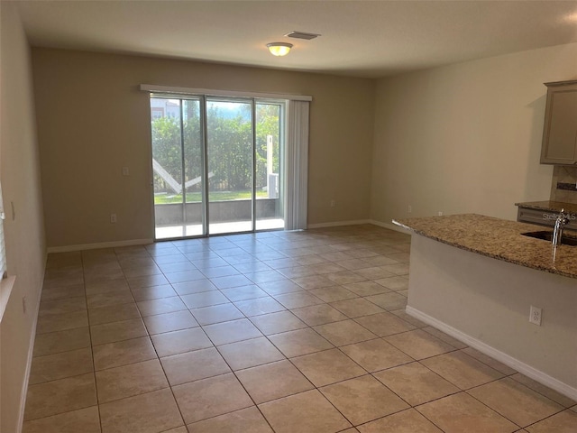 interior space featuring light tile patterned flooring and light stone countertops