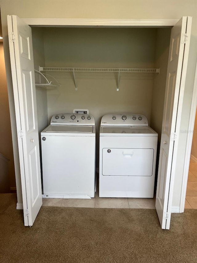 washroom with light tile patterned floors and washing machine and clothes dryer