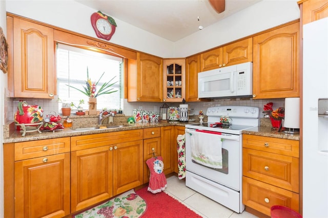 kitchen featuring light stone counters, tasteful backsplash, sink, white appliances, and light tile patterned floors