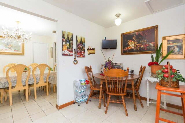 tiled dining room featuring a chandelier