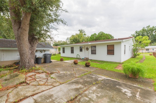 rear view of property with a lawn and a patio