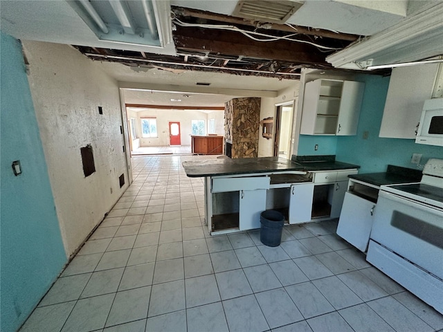 kitchen featuring white electric stove, light tile patterned floors, and white cabinets