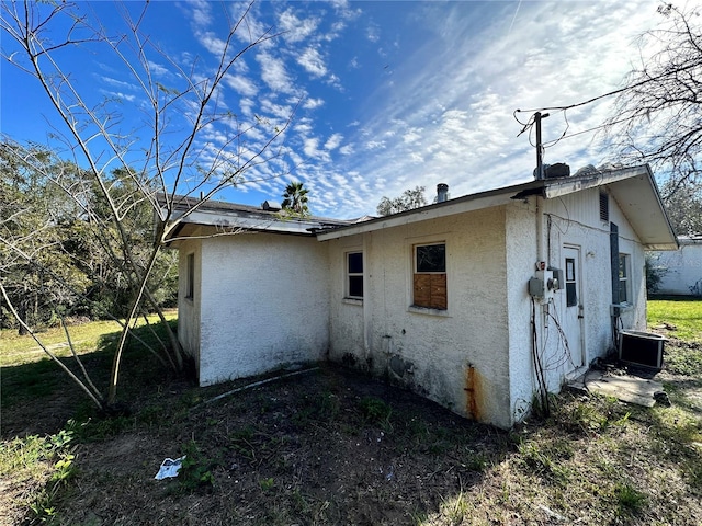 17025 Dalberg Dr, Spring Hill, FL 34610 - view of side of property with stucco siding and central AC unit
