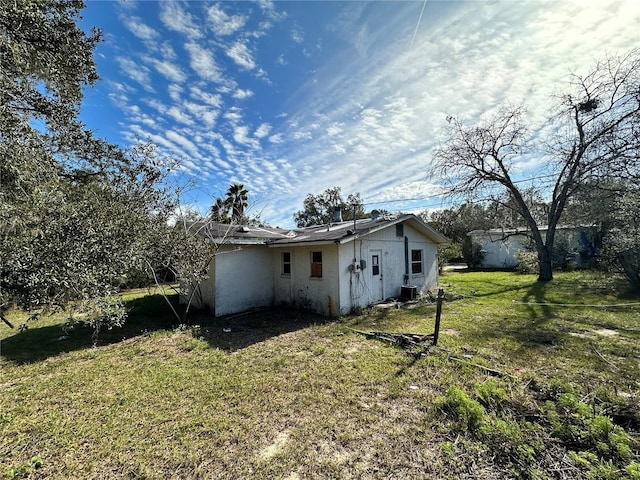 rear view of house with a lawn and central air condition unit