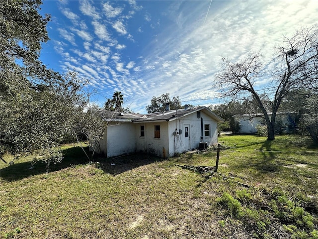 17025 Dalberg Dr, Spring Hill, FL 34610 - rear view of property with stucco siding, a lawn, and central air condition unit