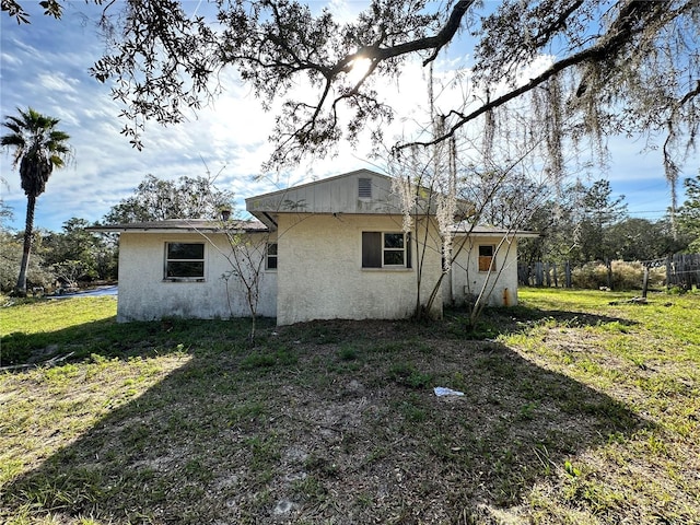 rear view of property featuring a lawn