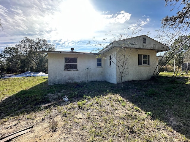 rear view of property featuring a lawn