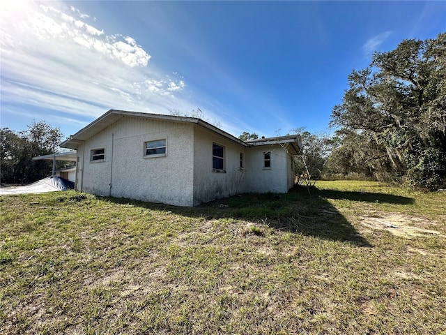 17025 Dalberg Dr, Spring Hill, FL 34610 - view of side of home featuring stucco siding and a lawn
