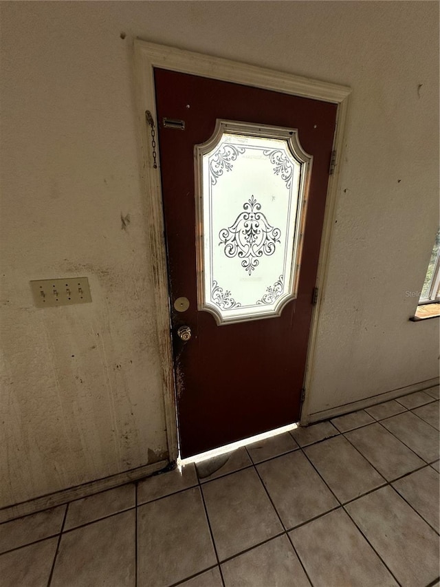 doorway with light tile patterned floors and a healthy amount of sunlight