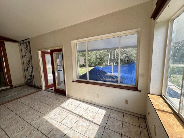 17025 Dalberg Dr, Spring Hill, FL 34610 - foyer featuring a textured wall, light tile patterned floors, plenty of natural light, and lofted ceiling