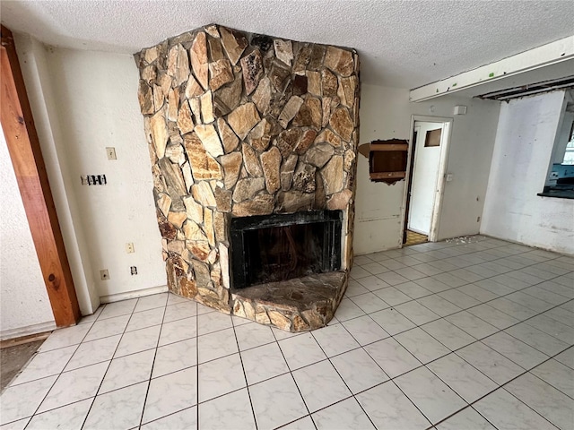 unfurnished living room with a textured ceiling, a fireplace, and light tile patterned floors