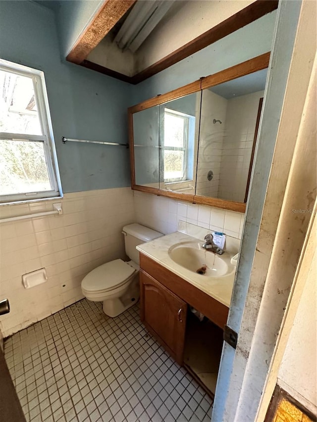 bathroom featuring tile walls, vanity, toilet, and tile patterned floors