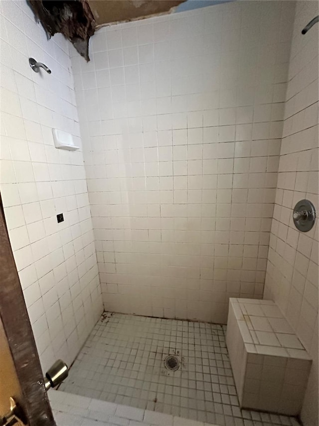 bathroom with tile patterned floors and tiled shower