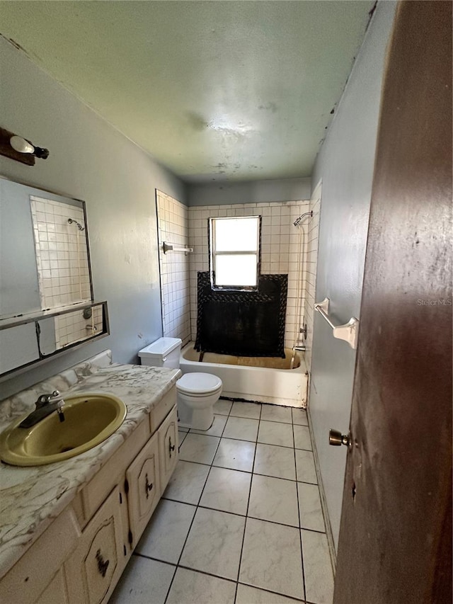 full bathroom with vanity, tiled shower / bath combo, toilet, and tile patterned floors