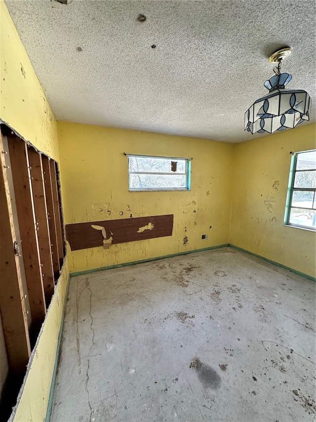 unfurnished room with a textured ceiling