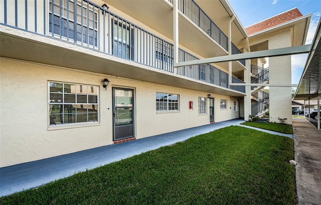 exterior space featuring a balcony and a lawn