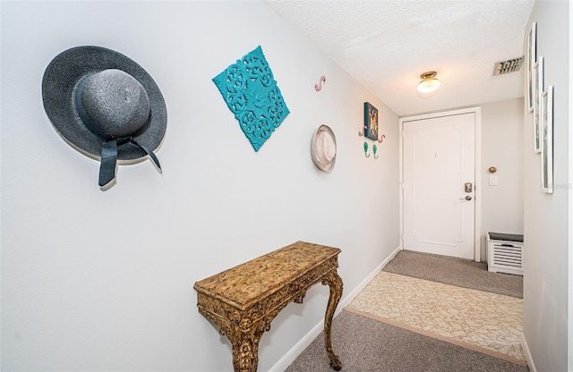 doorway with carpet flooring and a textured ceiling