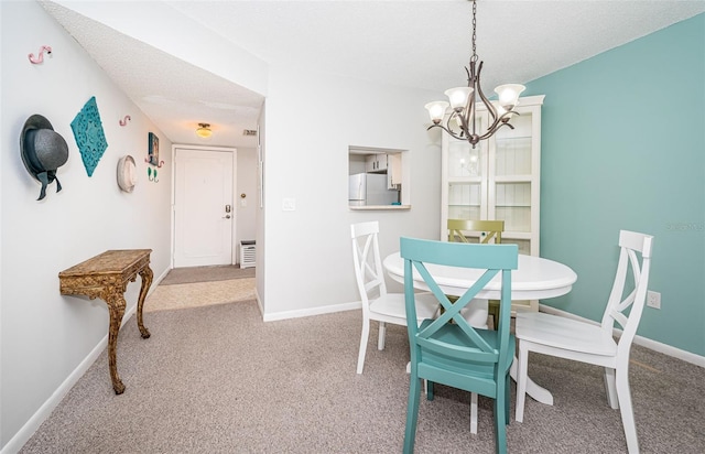 1450 Heather Ridge Blvd Unit 107, Dunedin, FL 34698 - carpeted dining room featuring a chandelier, baseboards, and a textured ceiling