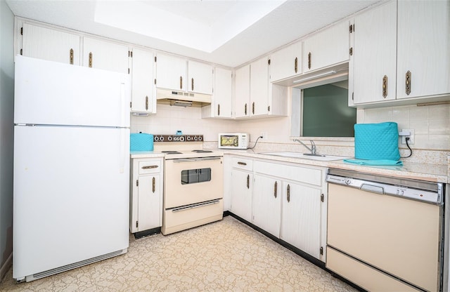 kitchen featuring sink, white cabinets, white appliances, and tasteful backsplash