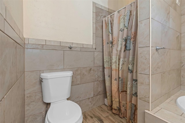 bathroom with walk in shower, tile walls, and toilet