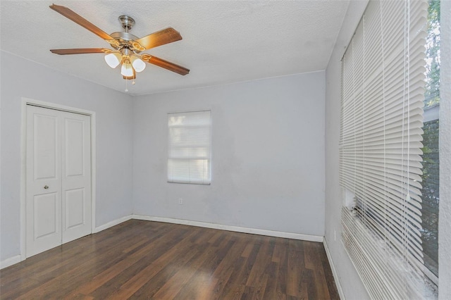 unfurnished bedroom featuring a closet, ceiling fan, dark hardwood / wood-style floors, and a textured ceiling