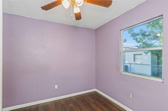 empty room featuring ceiling fan, a textured ceiling, and dark hardwood / wood-style flooring