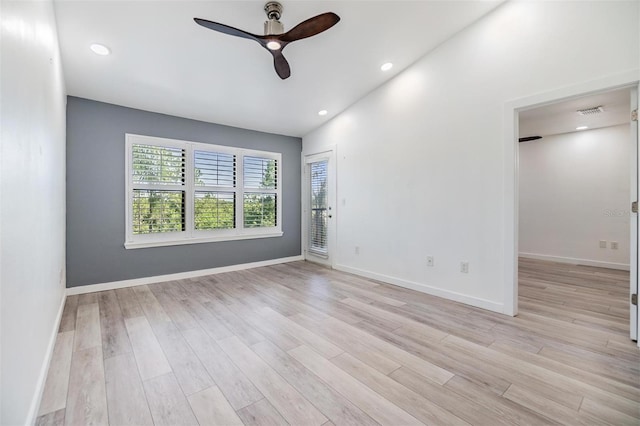 spare room with light hardwood / wood-style floors, vaulted ceiling, and ceiling fan