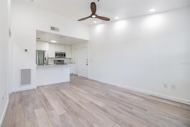 unfurnished living room featuring light wood-type flooring and ceiling fan