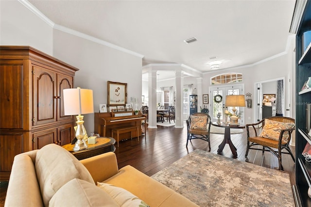 living room with decorative columns, ornamental molding, and dark wood-type flooring