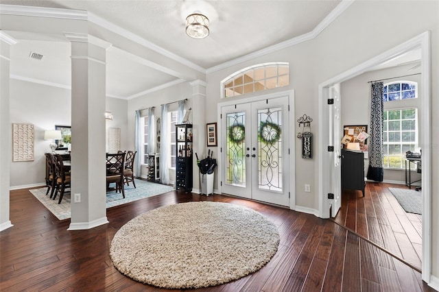 foyer entrance featuring french doors, ornamental molding, ornate columns, and dark hardwood / wood-style flooring