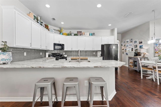 kitchen featuring dark wood-type flooring, white cabinets, kitchen peninsula, black appliances, and decorative light fixtures