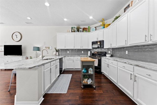 kitchen with a center island, dark hardwood / wood-style floors, sink, white cabinets, and black appliances