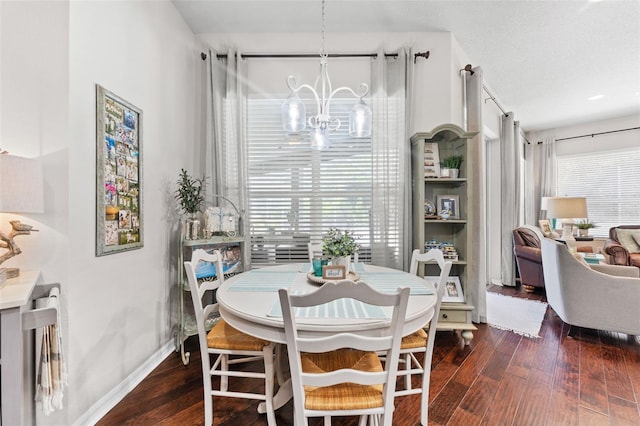 dining area with an inviting chandelier and dark hardwood / wood-style flooring