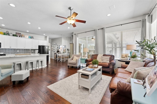 living room with ceiling fan, a textured ceiling, and dark hardwood / wood-style flooring