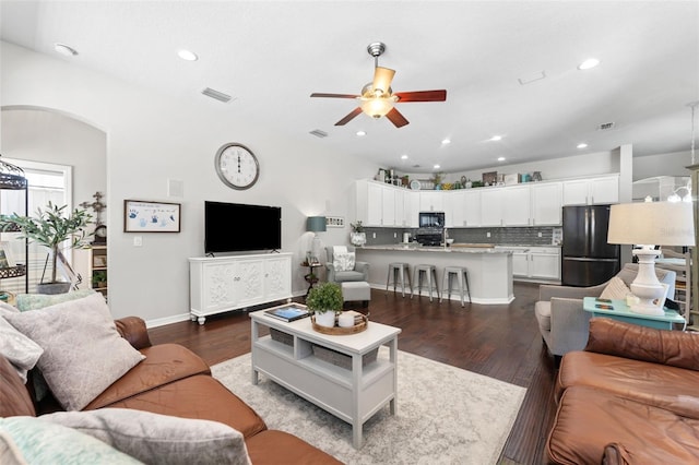 living room featuring dark hardwood / wood-style flooring and ceiling fan