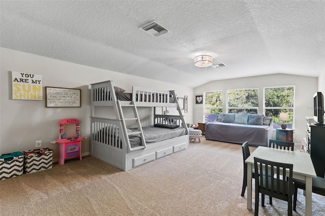 carpeted bedroom featuring a textured ceiling and lofted ceiling