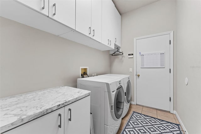 washroom featuring separate washer and dryer, cabinets, and light tile patterned floors