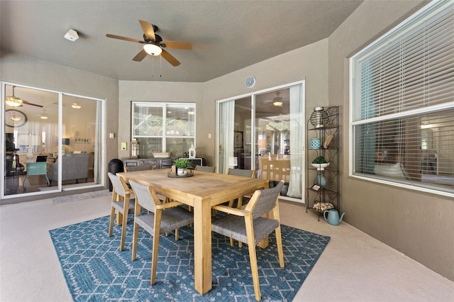 carpeted dining area featuring ceiling fan and a textured ceiling